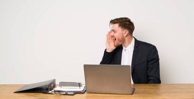 Bir ofiste işadamı yanal açık ağız ile bağırıyor