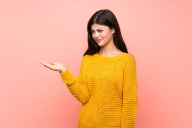 Şüphelerle copyspace tutan izole pembe duvar üzerinde Genç kız