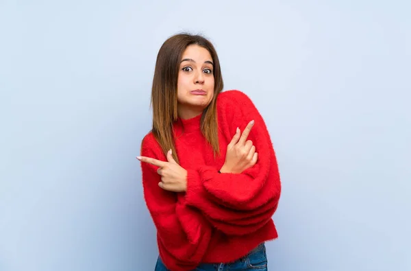 Junge Frau Über Isolierte Blaue Wand Die Auf Die Quereinsteiger — Stockfoto