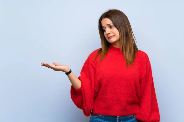 Mujer Joven Sobre Aislada Pared Azul Sosteniendo Copyspace Con Dudas — Foto de Stock