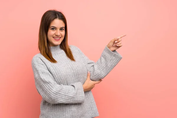 Jeune Femme Sur Mur Rose Pointant Doigt Sur Côté — Photo