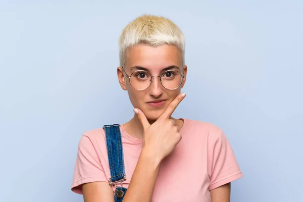 Teenager Mädchen Mit Overalls Blauer Wand Steht Und Denkt Eine — Stockfoto