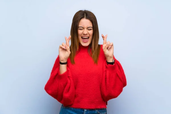 Jonge Vrouw Geïsoleerde Blauwe Muur Met Vingers Oversteken — Stockfoto