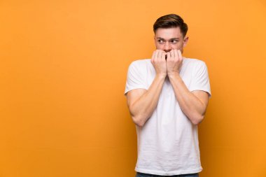 Kahverengi duvar üzerinde Redhead adam sinirli ve ağız ellerini koyarak korkmuş