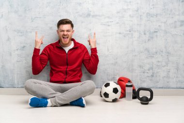 Kızıl saçlı spor adam rock jest yapma