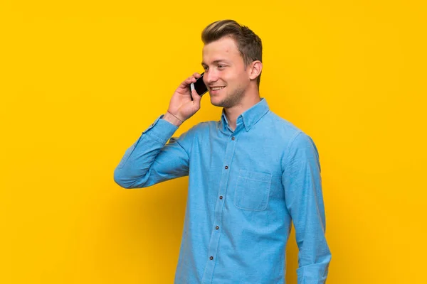 Blonde Man Isolated Yellow Wall Keeping Conversation Mobile Phone — Stock Photo, Image