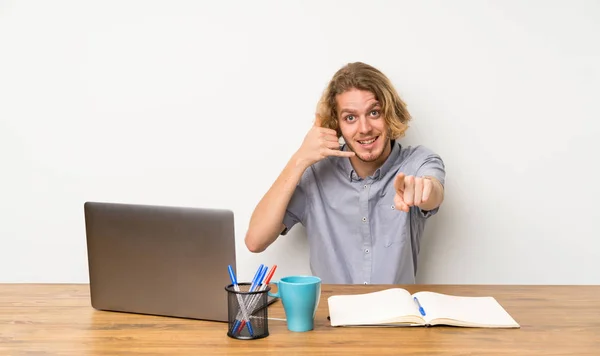 Ξανθός Άνθρωπος Ένα Laptop Κάνοντας Χειρονομία Τηλέφωνο Και Δείχνοντας Μπροστά — Φωτογραφία Αρχείου