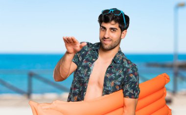 Plaja reklam eklemek için copyspace tutan sandıklı adam