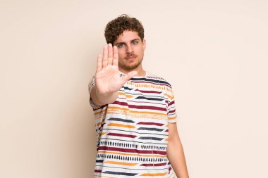 Izole duvar üzerinde Sarışın adam stop jest yapma