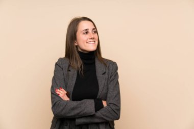 İzole edilmiş duvarın üzerinde duran ve yana bakan genç bir kadın.