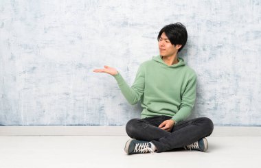 Asyalı adam şüphelerle copyspace tutarak katta oturan