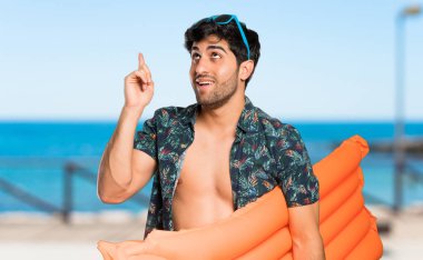 Plajda parmağını kaldırırken çözümü gerçekleştirmek isteyen sandıklı adam