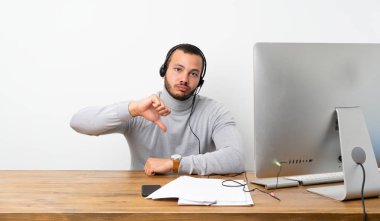 Telemarketer Kolombiyalı adam olumsuz ifade ile başparmak aşağı gösteren