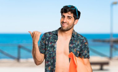 Plajda bir ürün sunmak için yan işaret şort adam