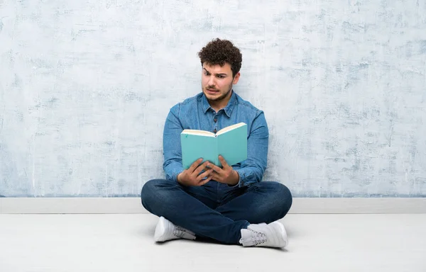 Giovane Seduto Sul Pavimento Che Tiene Legge Libro — Foto Stock