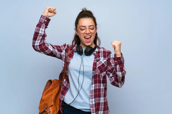 Tiener Student Meisje Geïsoleerde Blauwe Muur Vieren Een Overwinning — Stockfoto