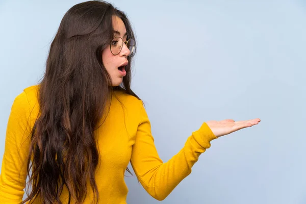 Menina Adolescente Sobre Parede Azul Isolado Segurando Copyspace Imaginário Palma — Fotografia de Stock