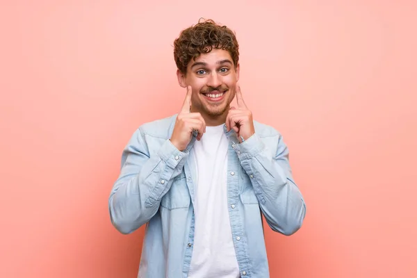 Blonde Man Roze Muur Glimlachend Met Een Gelukkige Aangename Uitdrukking — Stockfoto