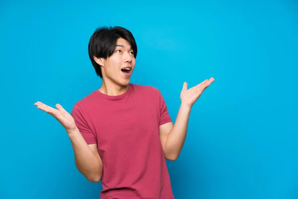 Asian Man Red Shirt Isolated Blue Wall Surprise Facial Expression — Stock Photo, Image