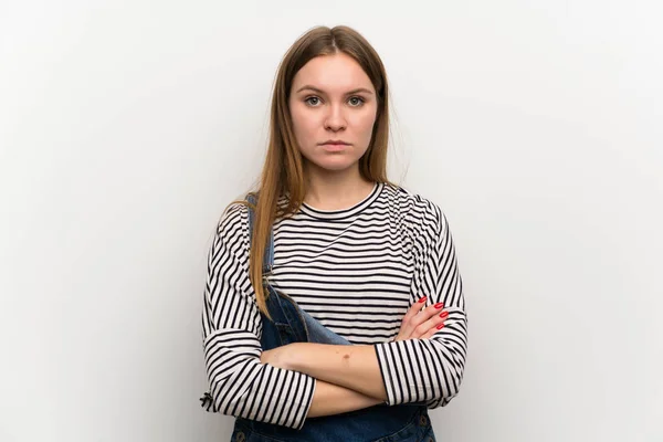 Junge Frau Latzhose Über Weiße Wand Mit Verschränkten Armen — Stockfoto