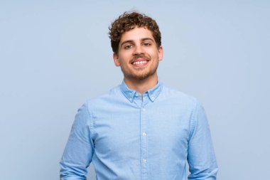 Mavi duvar gülüyor üzerinde sarışın adam