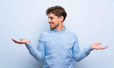 Mavi duvar boşaltmak iki elle tutarak sarışın adam