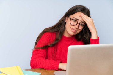 Bir masada okuyan sinirli genç öğrenci kız