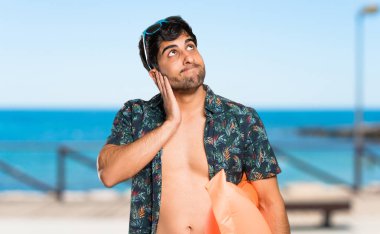 Şortlu adam sahilde bir fikir düşünüyor