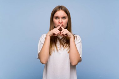 Sessiz jest bir işareti gösteren mavi duvar üzerinde genç kadın