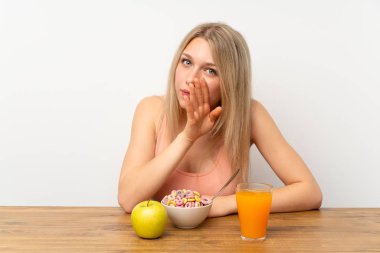 Genç sarışın kadın kahvaltıda bir şeyler fısıldıyor