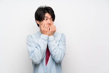 Izole beyaz arka plan sinirli Asyalı adam ve ağızellerini koyarak korkmuş