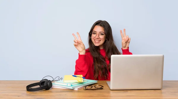 Adolescente Estudiante Chica Estudiando Una Mesa Mostrando Signo Victoria Con — Foto de Stock