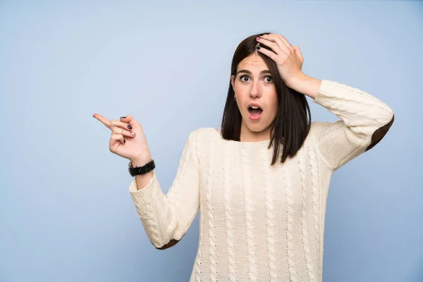 Mujer Joven Sobre Pared Azul Aislada Señalando Dedo Hacia Lado —  Fotos de Stock