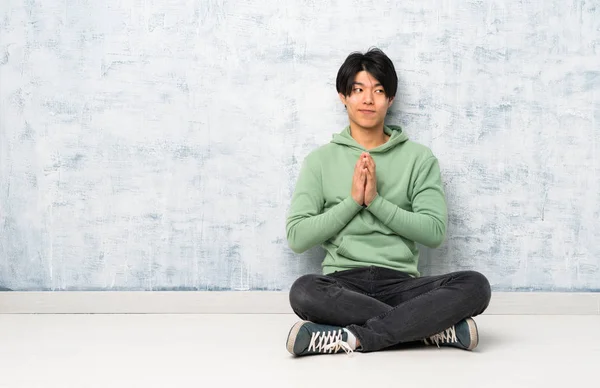 Asiatischer Mann Sitzt Auf Dem Boden Und Intrigiert — Stockfoto