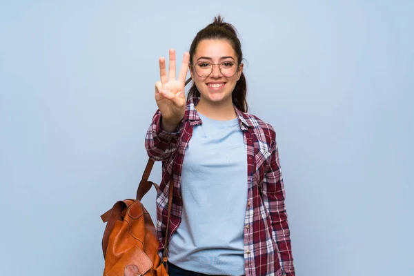 Dívčí Studentka Přes Izolovanou Modrou Zeď Šťastná Tři Prsty — Stock fotografie
