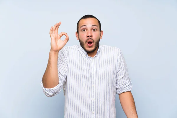 Kolumbianer Über Vereinzelte Blaue Wand Überrascht Und Zeigt Zeichen — Stockfoto