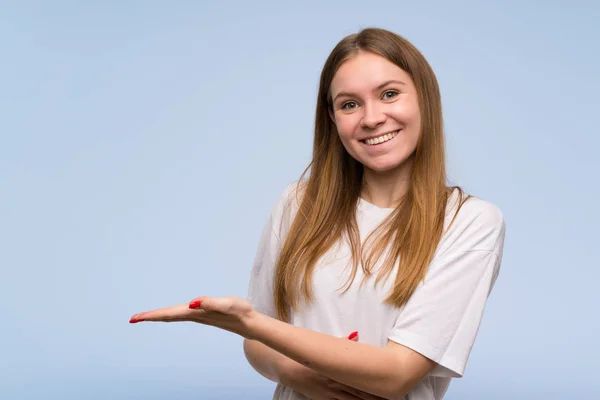 Jonge Vrouw Blauwe Muur Een Idee Presenteren Terwijl Uitziende Glimlachend — Stockfoto