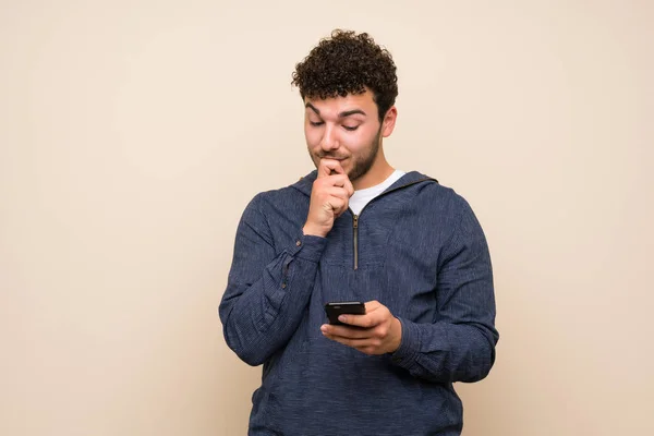 Homme Aux Cheveux Bouclés Sur Mur Isolé Pensant Envoyant Message — Photo