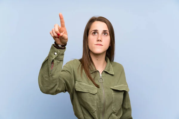 Zole Edilmiş Mavi Duvarda Genç Bir Kadın Şeffaf Ekrana Dokunuyor — Stok fotoğraf