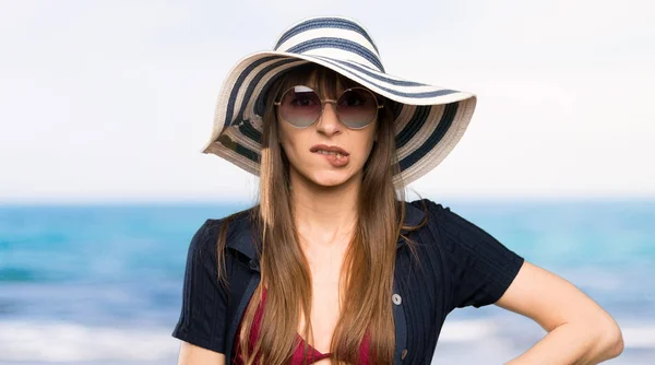 Young woman in bikini having doubts and with confuse face expression at the beach