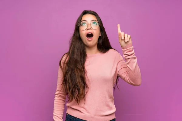 Дівчина Підліток Над Фіолетовою Стіною Вказує Вгору Здивований — стокове фото