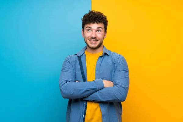 Homem Com Cabelo Encaracolado Sobre Parede Colorida Olhando Para Cima — Fotografia de Stock