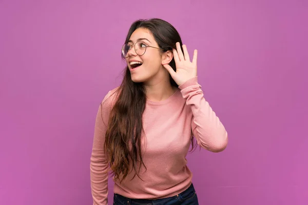Menina Adolescente Sobre Parede Roxa Ouvindo Algo Colocando Mão Ouvido — Fotografia de Stock