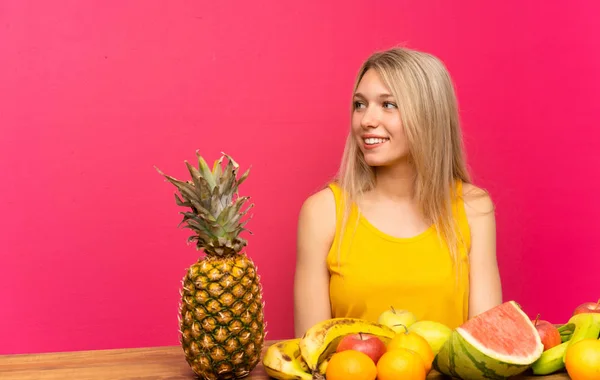 Mujer Rubia Joven Con Montón Frutas Mirando Lado — Foto de Stock
