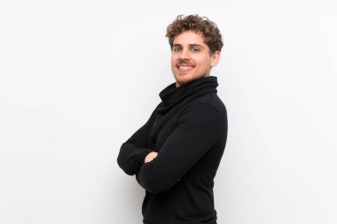 Kolları geçti ve ileriye bakan izole beyaz duvar üzerinde Blonde adam