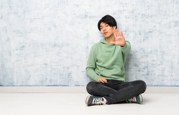 Asiatischer Mann Sitzt Auf Dem Boden Und Macht Stop Geste — Stockfoto