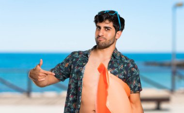 Şortlu adam plajda gururlu ve kendinden memnun