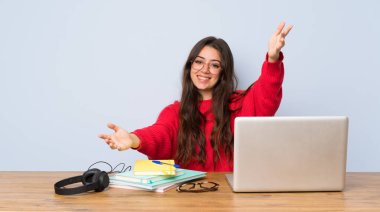 Genç öğrenci kız sunan bir tabloda okuyan ve el ile gelmek için davet