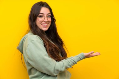 Gelmek için davet için yan ellerini uzatan sweatshirt ile genç kız