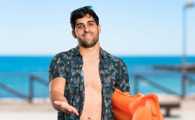 Plaja bir reklam eklemek için avuç içinde copyspace hayali tutan şort adam